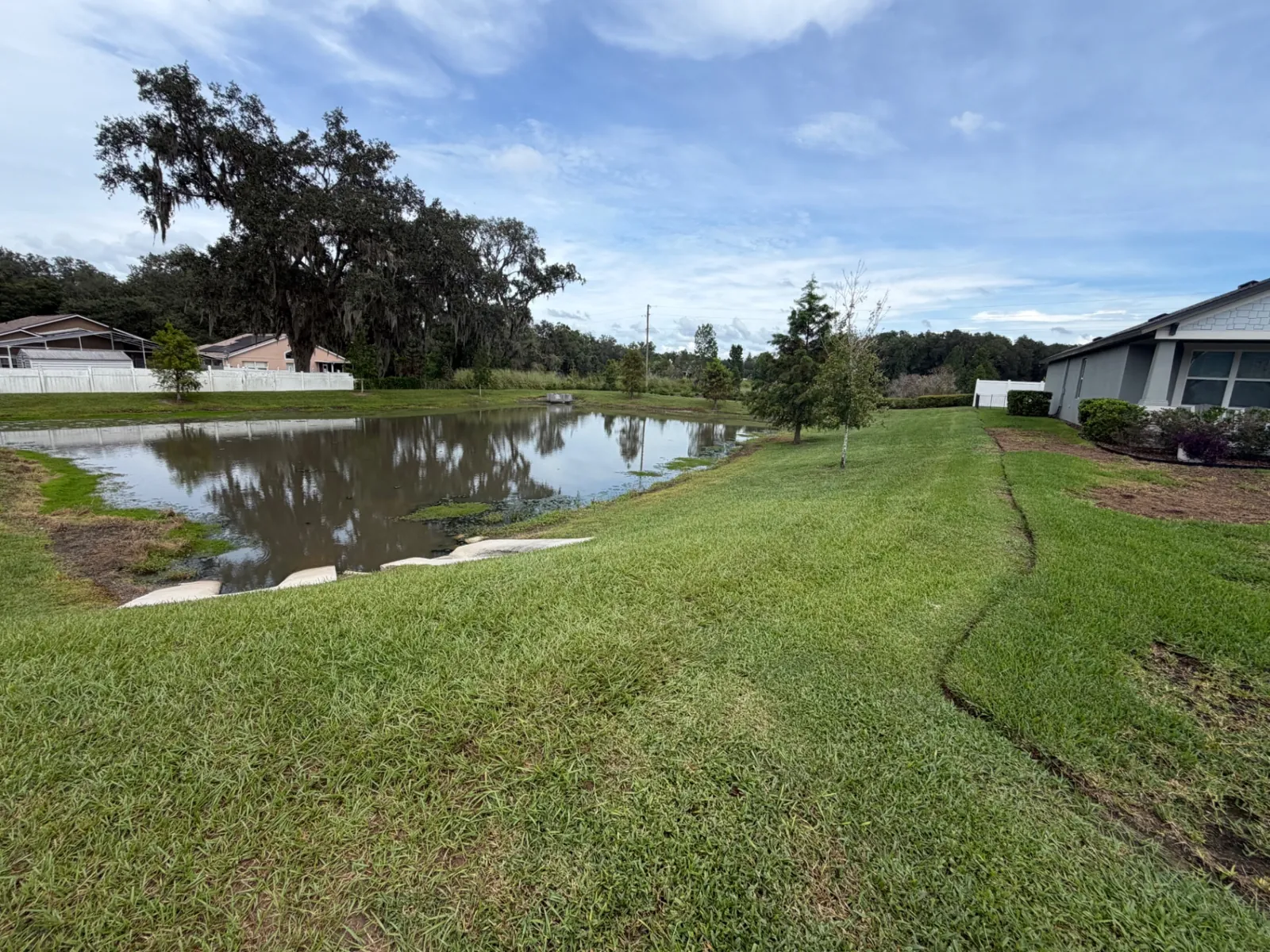 Neatly cut pond bank and edged landscape bed