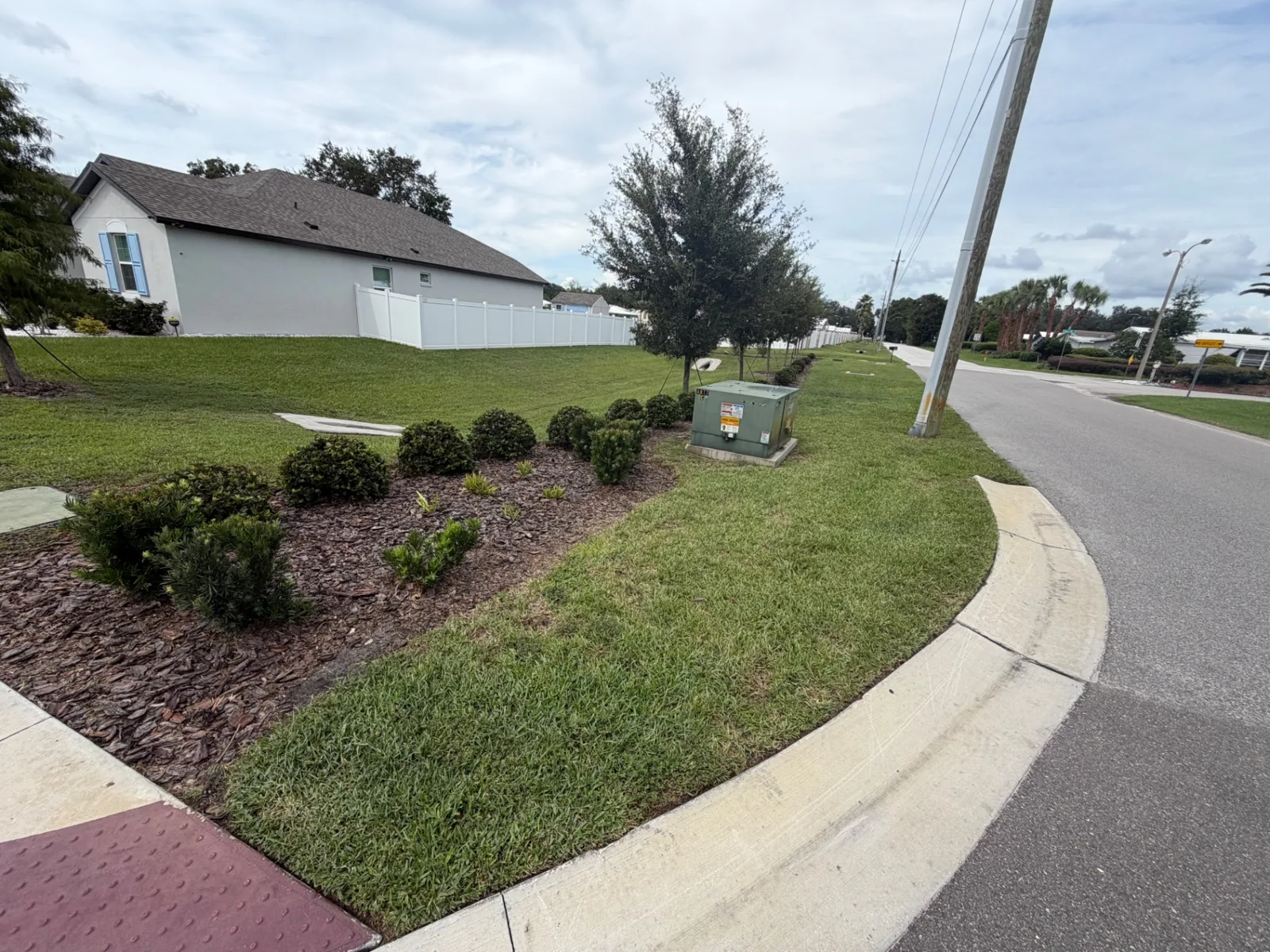 Mulched shrub bed and edged curb at a community corner